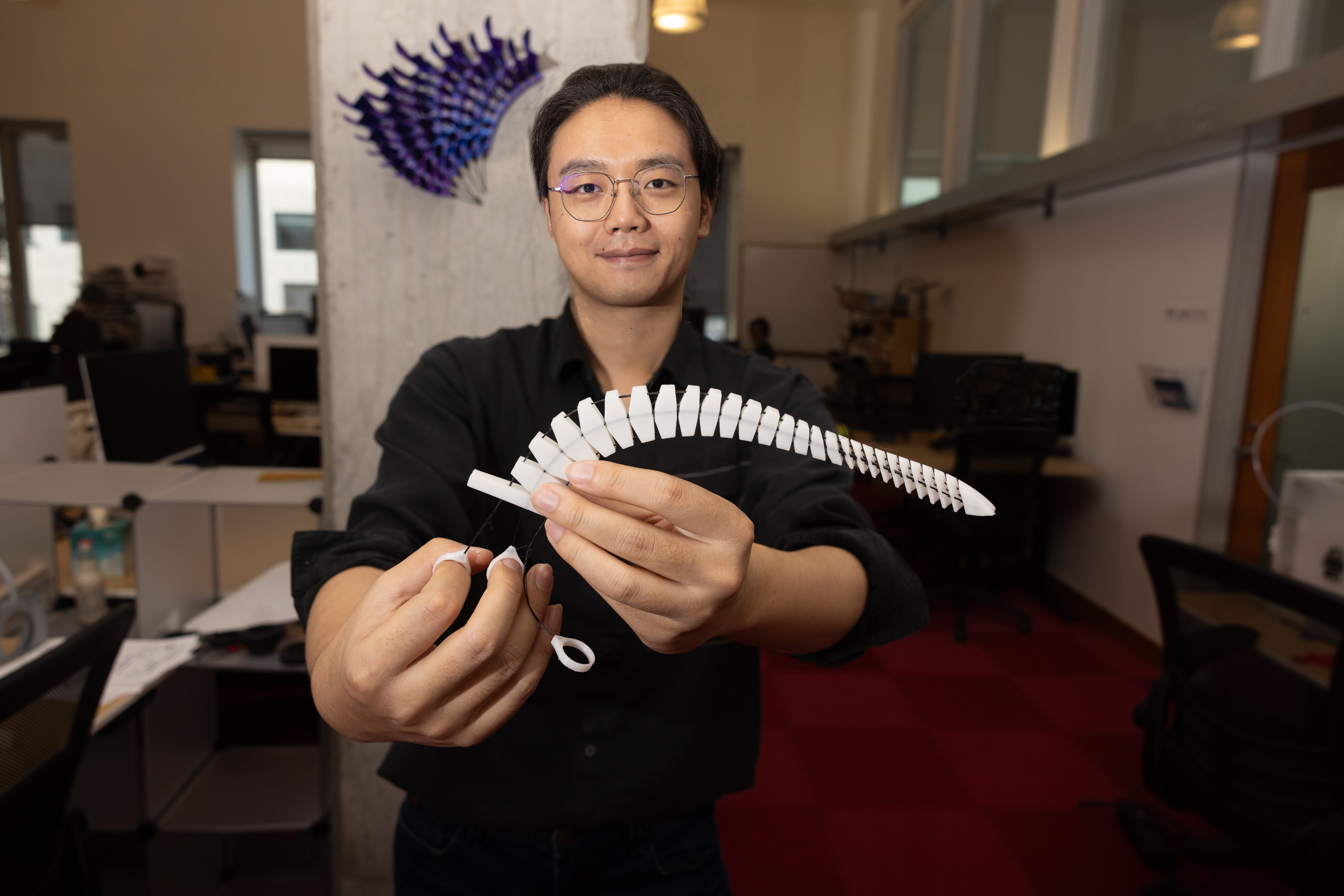 The “Xstrings” method can produce a range of colorful and unique objects, like a white tentacle that curls around items and a purple wall sculpture that can open and close (Credit: Mike Grimmett/MIT CSAIL).